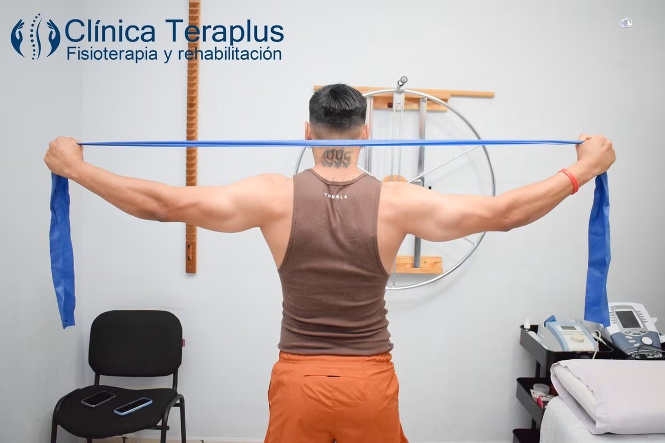 Paciente realizando ejercicio de rehabilitación con banda elástica en Clínica Teraplus